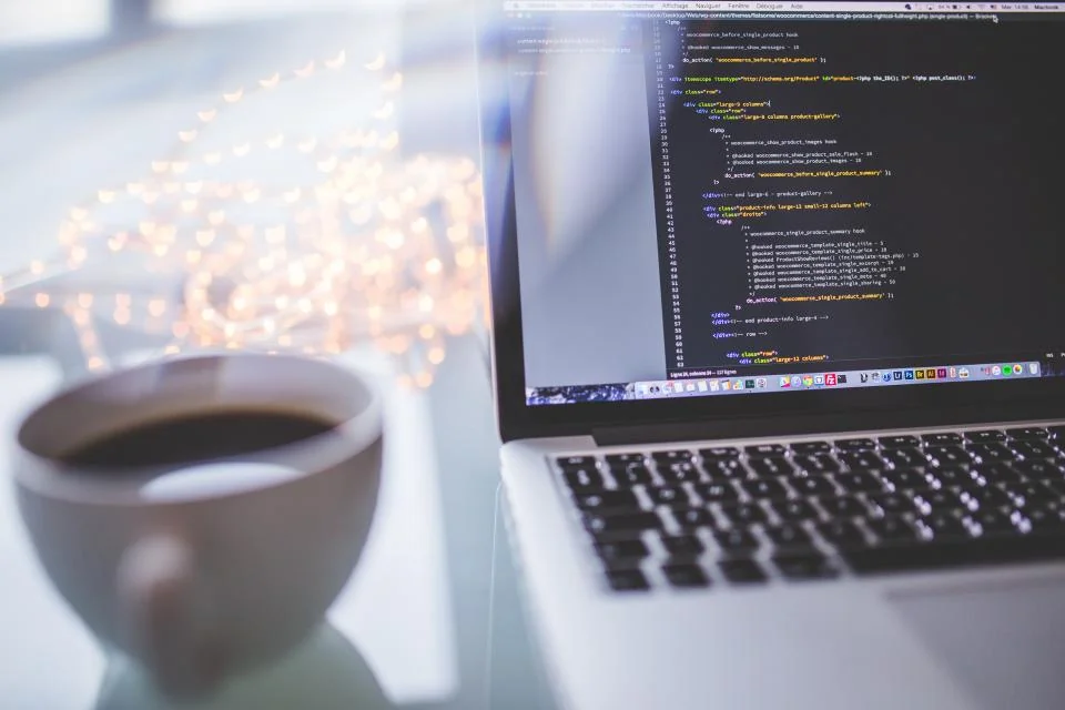 Laptop with code and coffee in a GSAP and Lenis dev setup